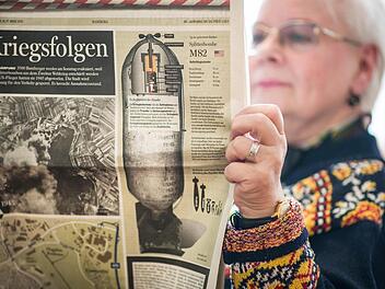 Eine Dame liest am 17.03.2013 in der Evakuierungs-Sammelstelle im Eichendorff-Gymnasium in Bamberg eine Ausgabe des Fränkischen Tags, die auf Sonderseiten über die Evakuierung und Kriegsfolgen im Allgemeinen informiert.