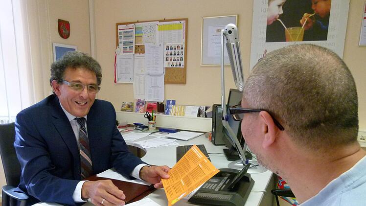 Mohamed Hédi Addala informiert in seiner Sprechstunde Ali Mahmoud über die Wahl des Migranten- und Integrationsbeirats.                 Foto: MarionKrüger-Hundrup