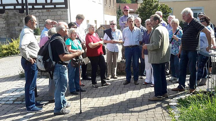 Aufmerksame Zuhörer: Roland Heinlein vom Kulturbüro (rechts) vermittelt in lockerer Form Historisches und Sehenswertes beim Stadtspaziergang durch Bad Brückenau. Foto: Rolf Pralle
