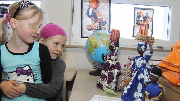 Lucy und Emily finden die afrikanischen Puppen klasse.  Fotos: Richard Sänger