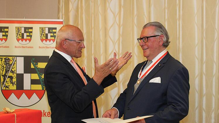 Günther Denzler (l.) überreicht Peter Landendörfer die Ehrenmedaille des Bezirks Oberfranken. Foto: Carmen Schwind
