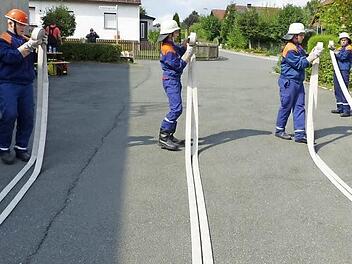 Das Aufrollen eines C-Schlauches geht dem Harsdorfer Team gekonnt von der Hand. Fotos: Klaus-Peter Wulf