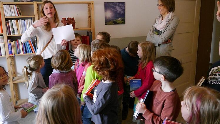 Aufmerksam verfolgen die Erstklässler die Fragen von Astrid Wirth beim Büchereiquiz. Klassenlehrerin Caroline Karner assistiert. Foto: Oswald Türbl