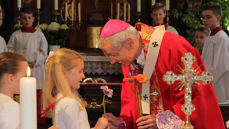 Die Kommunionkinder begrüßen den Erzbischof mit Blumen. Foto: Mathias Erlwein
