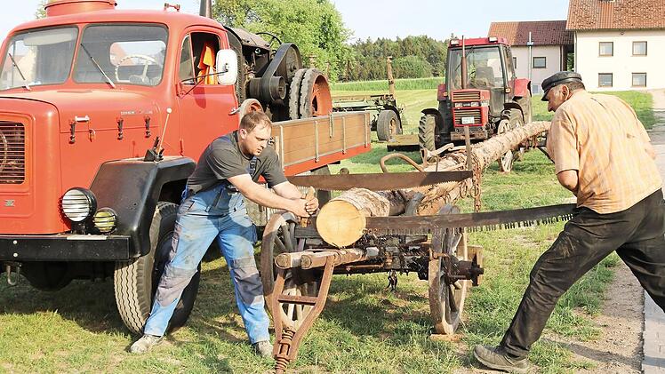 Matthias und Walter Lehnert (von links) üben sich schon einmal im Sägen mit einer alten manuellen Zugsäge. Sie stecken mitten in den Vorbereitungen für das Festwochenende am 26. und 27. Mai. Foto: Janina Reuter
