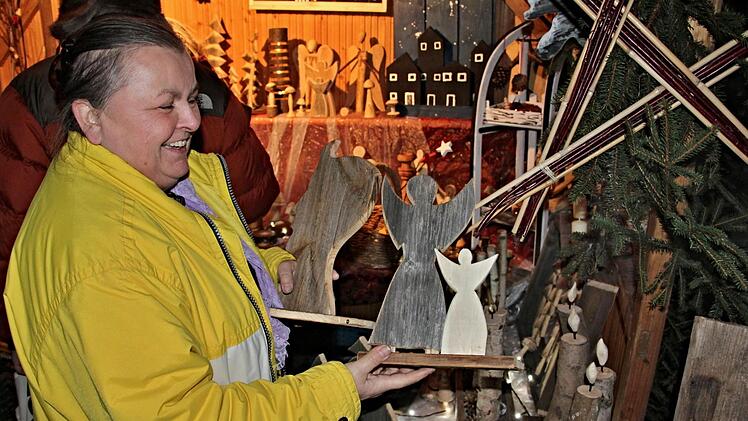 Weihnachtliche Symbole aus 200 Jahre altem Holz von einer Scheune die abgerissen wurde, gab es an diesem Stand, worüber die Dame sich sichtlich freut.Will