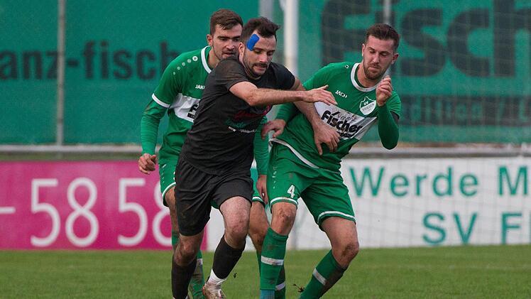 Gegen die Friesener Andreas Baier und Jonathan Müller (v.r.) versucht der Fuchsstadter Christoph Schmidt an den Ball zu kommen. Seine Mannschaft setzte sich in Friesen knapp durch. Foto: Heinrich Weiß