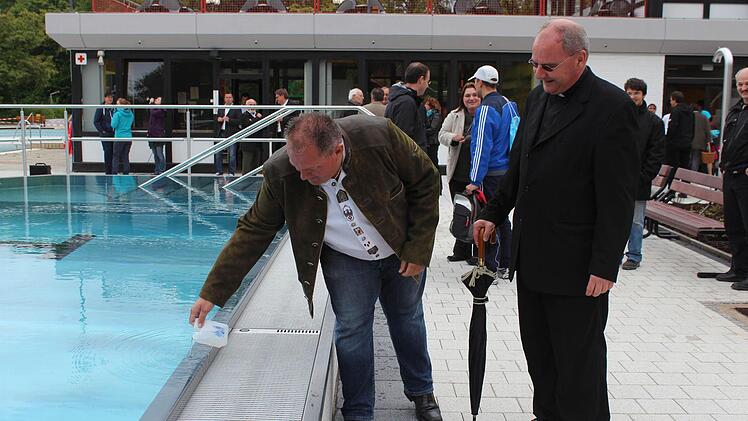 Sportzentrumsleiter Hans-Peter Philipp bekam von Dekan Kilian Kemmer Weihwasser fürs neue Becken. Foto: Andreas Dorsch