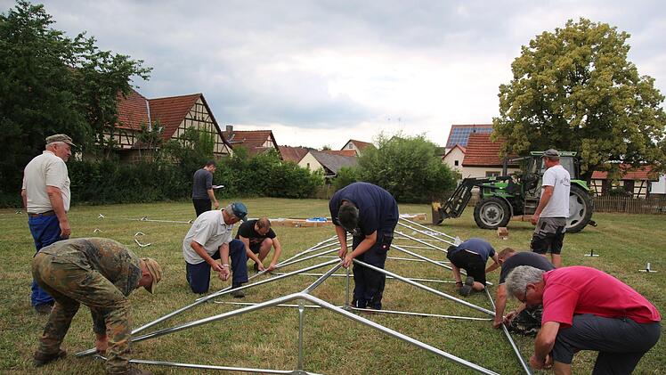 Wenn ein kleines Dorf feiert, helfen wie hier im Seßlacher Ortsteil Bischwind am Dienstag, viele Hände mit. Bis die nagelneuen Zelte auf der Festwiese stehen, braucht es viel Geduld. Bis zum großen Fest mit Matinée, historischen Gewerken wie Speisen sowie einem ausgefallenen Kinderprogramm am Sonntag, 24. Juni, wird alles stehen, da waren sich alle Helfer einig. Foto: Bettina Knauth