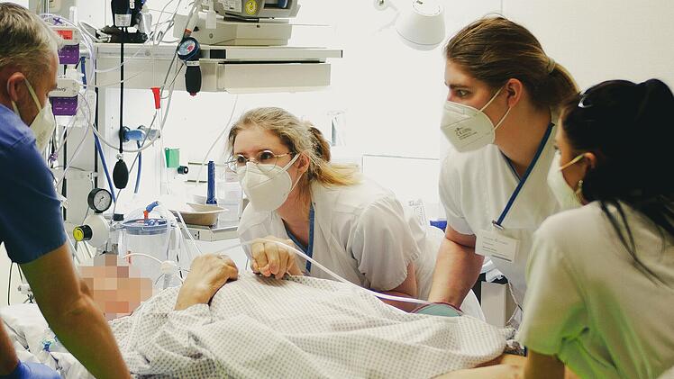 Die Arbeit auf der Intensivstation ist auch au&szlig;erhalb des Covid-Bereichs jeden Tag Schwerstarbeit. Gemeinsam mit einem Arzt betten drei Krankenpflegerinnen einen Patienten um.