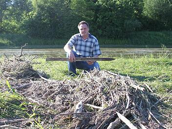 Landwirt Hermann Grampp auf einer Wiese am Weißen Main. Das Hochwasser hat dort eine riesige Menge an Ästen und Reisig angespült. Auch etliche Holzpfähle muss der Melkendorfer entsorgen. Fotos: Alexander Hartmann