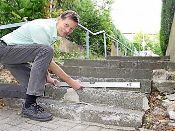 Peter Borst vom Servicebetrieb der Stadt Bad Kissingen zeigt, wie schief die Stufen der Treppe zwischen Salinen- und Friedrich-List-Straße sind, in wenigen Wochen sollen die Bauarbeiten starten.  Foto: Ralf Ruppert