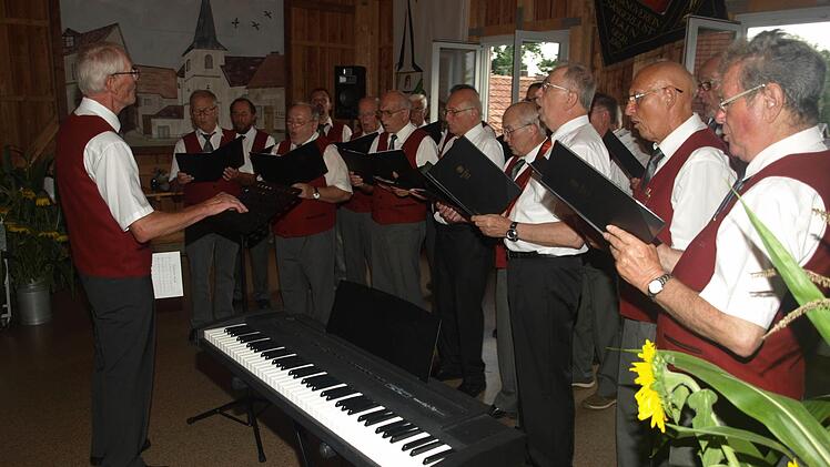 Der Männergesangverein Ebenhausen zählt zu den wichtigen Kulturträgern der Gemeinde und bereicherte das musikalische Geschehen in Gemeinde und Umgebung. Hier sang der Chor mit Dirigent Kurt Distler (links) beim Ehrenabend in Hain im Juli 2016. Foto: Stefan Geiger