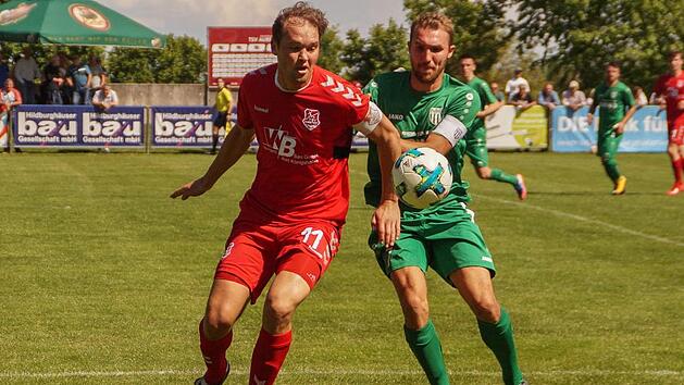 Im Kampf um den Ballbesitz begegnen sich der in der 57. Minute eingewechselte Aubstadter Julian Grell und der Sander Andr&eacute; Karmann. Foto: Rudi D&uuml;mpert