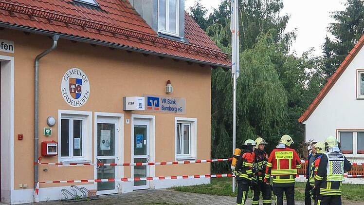 Einsatzkräfte der Feuerwehr besprechen sich am  13. Juni vor der VR-Bankfiliale in Stadelhofen. Dort war am Morgen der Geldautomat durch bisher Unbekannte gesprengt worden. Die Polizei prüft nun Zusammenhänge zu einem Fall in Bayreuth.News5/Merzbach (Archiv)