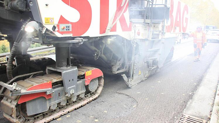 Hinter den Raupenketten wird der Asphalt maschinell abgefräst ...  Foto: Friedwald Schedel