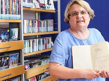Wie viele Lesungen sie schon organisiert hat, weiß BüchereiLeiterin Christine Wittenbauer nicht mehr. Von mancher Begegnung mit namhaften Autoren blieb eine Widmung im jeweiligen Buch als Erinnerung. Foto: Ramona Popp
