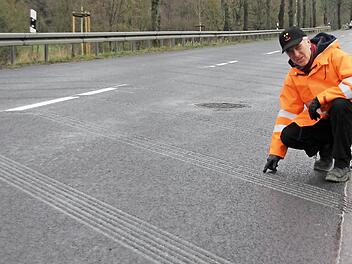 Jürgen Woll zeigt auf die Fräsrillen im Asphalt der Bundesstraße 303 bei Weißenbrunn.  Foto: Friedwald Schedel