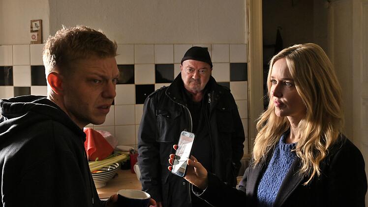 Falk Becker (Leonard Kunz, links) wird von Otto (Florian Martens) und Linett (Stefanie Stappenbeck) in die Mangel genommen.