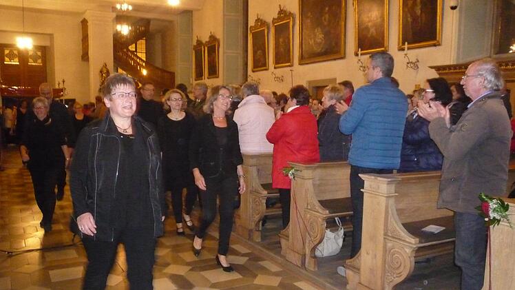Die ChorsängerInnen kommen von der Orgelempore und gehen zum Altar.