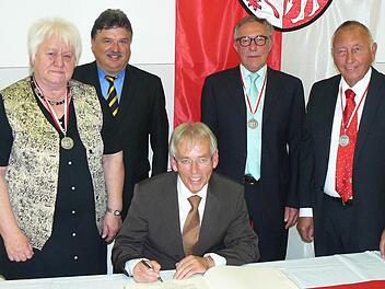 Wolfgang Wagner trägt sich beim Festakt im Gemeindesaal ins Goldene Buch der Gemeinde Untersteinach ein, die Bürgermedaillenträger Christa Müller und Peter Schuberth schauen ihm über die Schulter. Unser Bild zeigt (von links) Christa Müller, Landrat Klaus Peter Söllner, Wolfgang Wagner, Peter Schuberth und Bürgermeister Heinz Burges.  Foto: Klaus-Peter Wulf