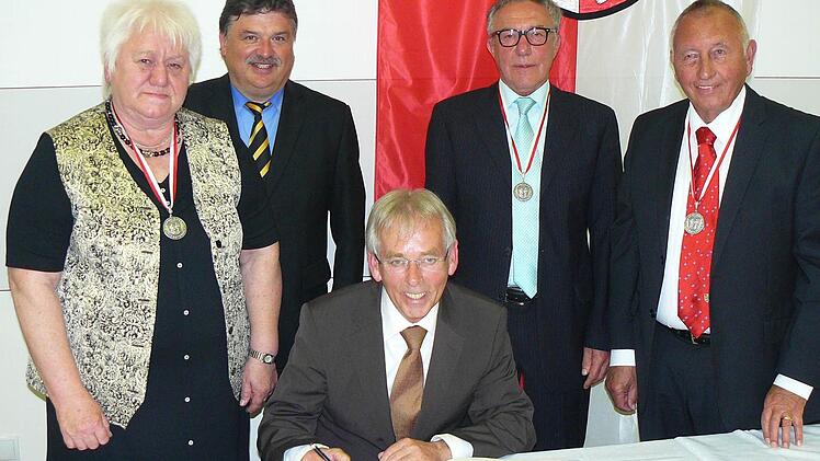 Wolfgang Wagner trägt sich beim Festakt im Gemeindesaal ins Goldene Buch der Gemeinde Untersteinach ein, die Bürgermedaillenträger Christa Müller und Peter Schuberth schauen ihm über die Schulter. Unser Bild zeigt (von links) Christa Müller, Landrat Klaus Peter Söllner, Wolfgang Wagner, Peter Schuberth und Bürgermeister Heinz Burges.  Foto: Klaus-Peter Wulf