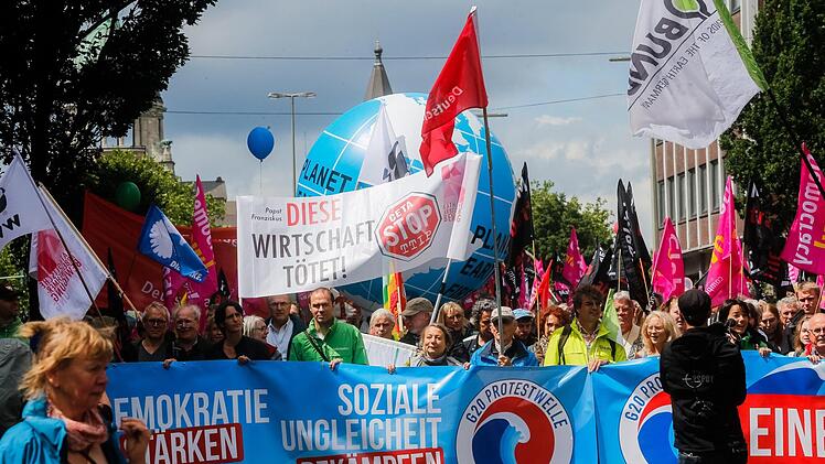 Teilnehmer der Demonstration "G20-Protestwelle" ziehen am 02.07.2017 in Hamburg mit einem Transparent mit der Aufschrift "Soziale Ungleichheit bekämpfen" durch die Innenstadt. Foto: Markus Scholz/dpa