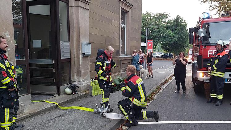 Mike Daum macht Katharina Wolf nach einer Scheinübung der Freiwilligen Feuerwehr im Münnerstädter Bahnhof einen Heiratsantrag. Einige Mitglieder waren eingeweiht, andere nicht. Auch einige Verwandte waren dazu gekommen. Foto: Daniel Röhlinger