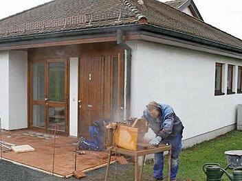 Uwe Gareis von der Firma Helmut Herrmann schneidet die Pflastersteine zu, sein Kollege Stefan Tasler verlegt sie vor der Leichenhalle. Foto: Sonja Adam
