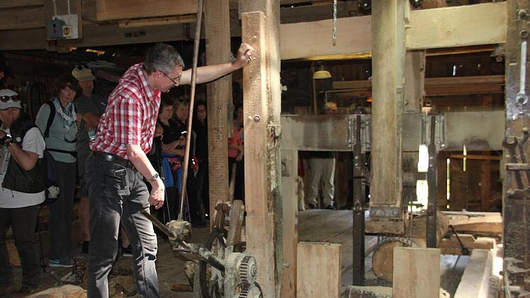 Jochen Umlauf zeigte den Wanderern die Funktionsweise der historischen Schneidmühle am Eingang von Wallenfels. Foto: Veronika Schadeck