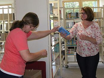 Karton für Karton packen Heike Kettemer und Sabine Loeber aus. Jedes Buch findet seinen Platz. Foto: Ulrike Müller