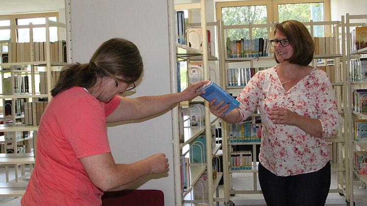 Karton für Karton packen Heike Kettemer und Sabine Loeber aus. Jedes Buch findet seinen Platz. Foto: Ulrike Müller