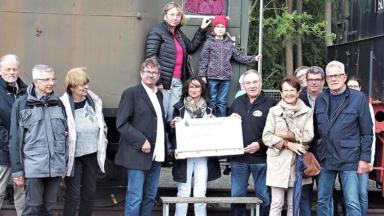 Scheckübergabe am preußischen Güterzugbegleitwagen; mit im Bild die stellvertretende UFC-Präsidentin Claudia Ebert (Mitte), Zweiter Vorsitzender Kurt Lang vom Förderverein DDM (rechts) und UFC-Präsident Thomas Holzmüller (links) sowie weitere Mitglieder des Unternehmerclubs Franken  Foto: privat