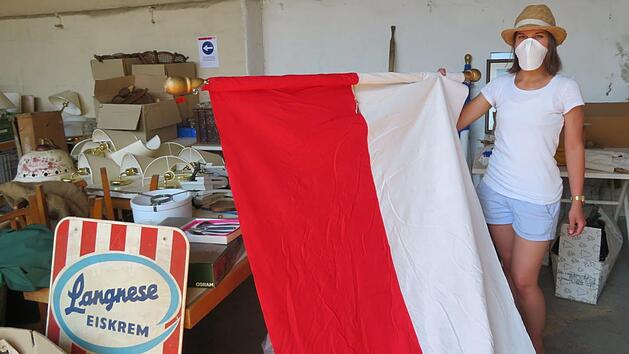 Christina Keller (Marktgemeinde) &uuml;berpr&uuml;ft die gut erhaltene Frankenfahne vor dem Verkauf. Foto: Monika Sch&uuml;tz