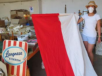 Christina Keller (Marktgemeinde) überprüft die gut erhaltene Frankenfahne vor dem Verkauf. Foto: Monika Schütz