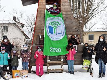 Die Kinder der Friedrich-Baur-Grundschule sowie Konrektorin Birgit Rupp (links) und Rektorin Susi Krauß (rechts) ließen es sich nicht nehmen, ihren Preis und die Umweltmülleimer im verschneiten Schulhof zu präsentieren.