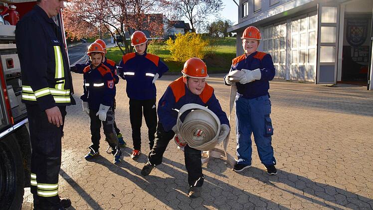 Linus lässt es sich nehmen und probiert aus, einen aufgerollten Schlauch wie ein Profi zu werfen. Thomas Geis (von links), Ramon, Simon, Daniel und Leon schauen dabei zu. Foto: Kathrin Kupka-Hahn