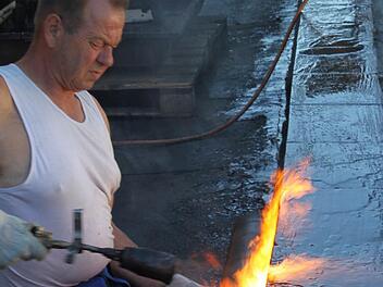 Klaus Staudt von der Firma Fuss & Gartenschläger aus Mainleus ist dabei, Schweißbahnen auf dem Dach anzubringen.  Foto: Jürgen Gärtner