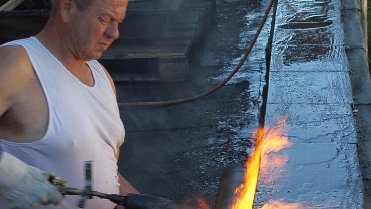 Klaus Staudt von der Firma Fuss & Gartenschläger aus Mainleus ist dabei, Schweißbahnen auf dem Dach anzubringen.  Foto: Jürgen Gärtner
