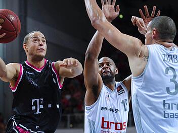 Die Bamberger Sharrod Ford (M) und Maik Zirbes (r) versuchen den Bonner Andrej Mangold zu blocken. Das Spiel endete 88:68 f&uuml;r die Brose Baskets. Foto: David Ebener/dpa