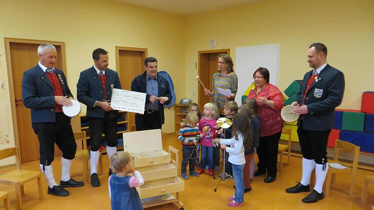 Einen Schrank voller Musik bekamen die Kinder im Kothener Kindergarten von Matthias Kraus (hinten links), Tobias Bauer (daneben) und Markus Witzel (rechts) vom Musikverein Kothen überreicht. Pfarrer Michael Krammer (Mitte), Kindergartenleiterin Sandra Reith (daneben) und Monika Solleder freuen sich über das Geschenk. Foto: Matthias Kraus