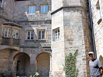 Miteigentümer Schardt vor romantischer Kulisse im Innenhof des Redwitzer Schlosses. Schwere Bauschäden finden sich im Inneren. Foto: Popp