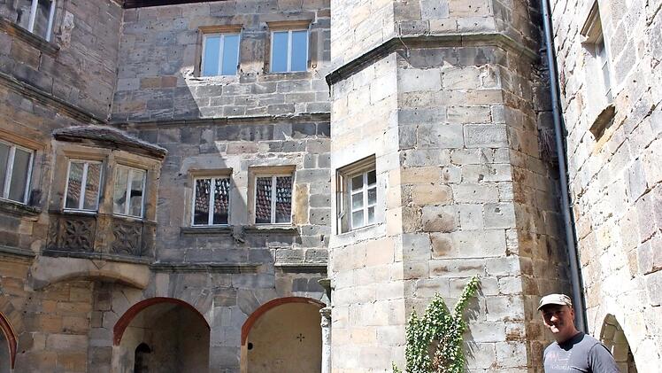 Miteigentümer Schardt vor romantischer Kulisse im Innenhof des Redwitzer Schlosses. Schwere Bauschäden finden sich im Inneren. Foto: Popp