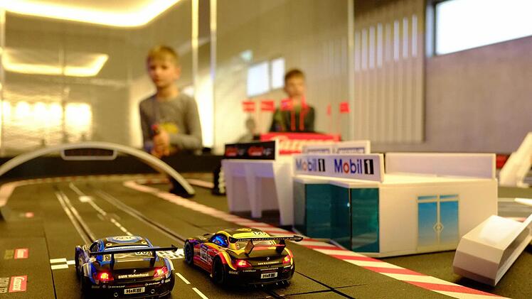 Zwei Spielzeug-Rennautos stehen auf einer Carrera-Bahn zum Start bereit. Foto: Nikolas Pelke