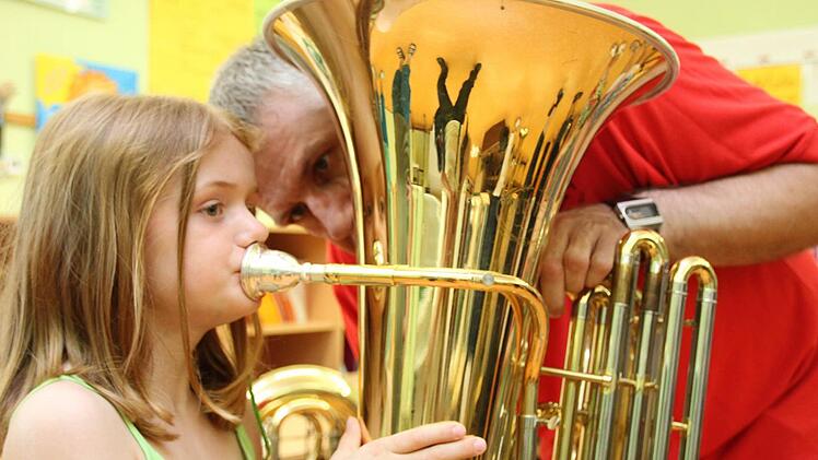 Lena (7) probiert eine Tuba aus, Thomas Bogner von den Eschenbacher Musikanten hilft ihr. Foto: Markus Reeh