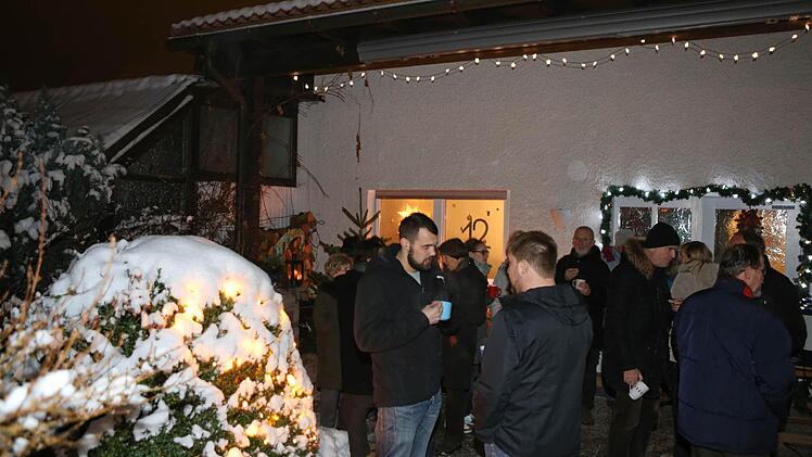 Man steht auf der Terrasse vor dem Adventsfenster (Hintergrund).