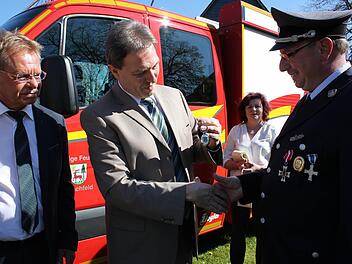 Klaus Löffler (Mitte) überreichte den Autoschlüssel des neuen Fahrzeuges an den Kommandanten Thomas Wachter. Mit im Bild der stellvertretender Landrat Wolfgang Beiergrößlein (links). Foto: Veronika Schadeck