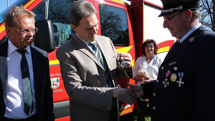 Klaus Löffler (Mitte) überreichte den Autoschlüssel des neuen Fahrzeuges an den Kommandanten Thomas Wachter. Mit im Bild der stellvertretender Landrat Wolfgang Beiergrößlein (links). Foto: Veronika Schadeck