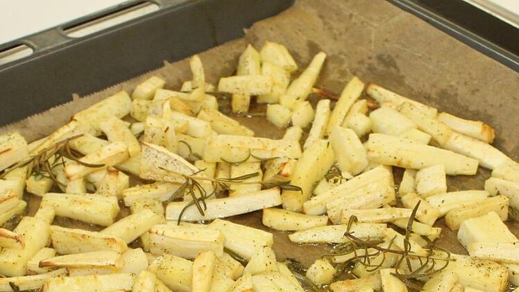 Auf dem Blech die Pastinakenstücke mit Olivenöl, Thymian und Rosmarin 20 Min bei 200 Grad im Ofen braten.