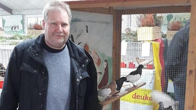 Vorsitzender des SV der Elsterpurzler, G&uuml;nter Vitzthum, vor einer Schauvoliere mit Elsterpurzlern. Foto: Rainer Wilm